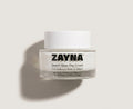 ZAYNA Desert Glow Day Cream in a clear glass jar with a white lid, featuring Argan oil and hyaluronic acid formula.